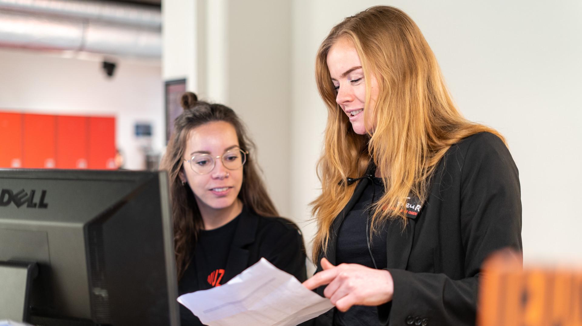 Twee medewerkers aan het werk bij de balie