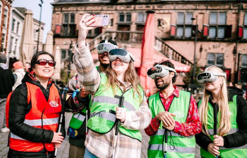 Gids Melly en een aantal bezoekers maken een selfie tijdens Expeditie ribbelroute op de grote markt