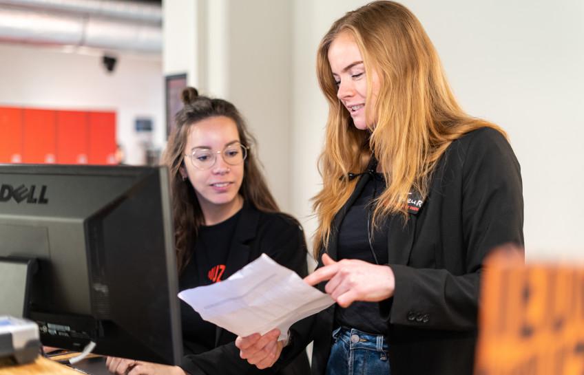 Twee medewerkers aan het werk bij de balie